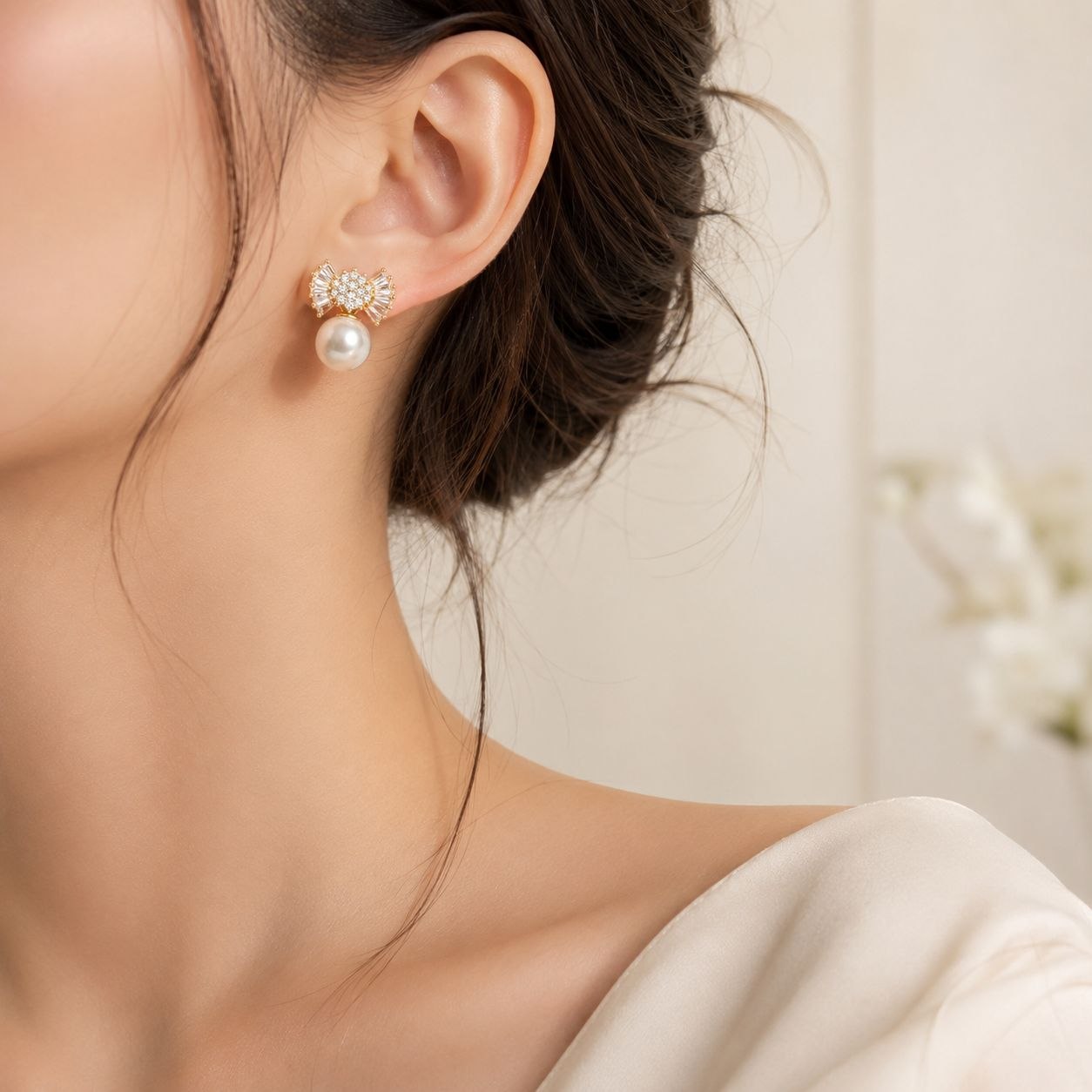 ARETES DE ENCHAPE PARA DAMA CON MOTIVO DE MOÑO EN PAVÉ Y CIRCONES BAGUETTE CON PERLA