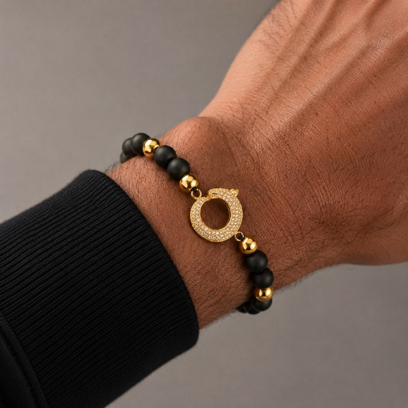 PULSERA AJUSTABLE PARA CABALLERO CON CUENTAS NEGRAS MATE Y DIJE CIRCULAR ENCHAPADO CON PAVÉ DE CIRCONES